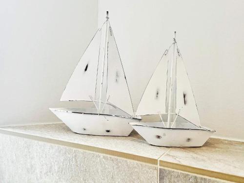two model boats sitting on a shelf at Cozy Modern Apartment with Sea Views in Wendtorf