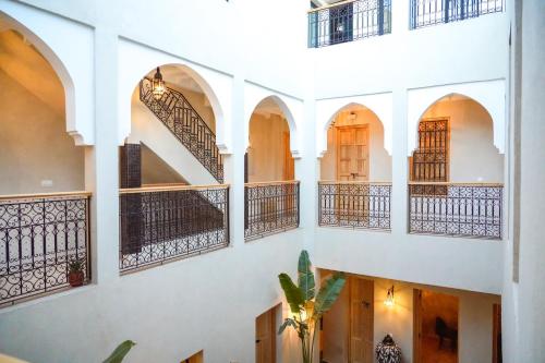 a courtyard with arches and balconies in a building at Riad Citrus By La Siredrah in Marrakech