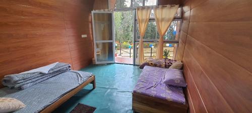 a room with two beds and a sliding glass door at New bloom homestay in Mangpu