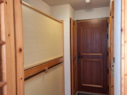 une porte ouverte menant à une chambre avec une porte en bois dans l'établissement Agréable studio avec balcon proche des pistes à Chamonix, parking inclus - FR-1-517-52, à Chamonix-Mont-Blanc