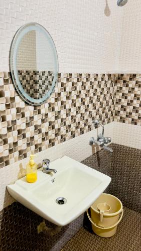 a bathroom with a white sink and a mirror at Prince Castle-4BHK Apartment,Guesthouse in Hyderabad