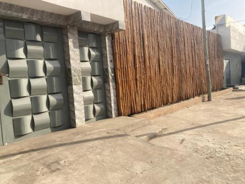 un edificio con una valla de madera junto a una acera en Lome Bamboo Lodge, en Lomé