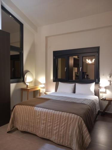 een hotelkamer met een groot bed met 2 lampen bij The Zen Point detox suites in Marathopolis