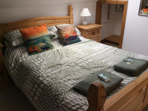 ein Bett mit zwei Fernbedienungen auf dem Bett in der Unterkunft The Burrows (ladybird lodgings) in Stoke Gabriel