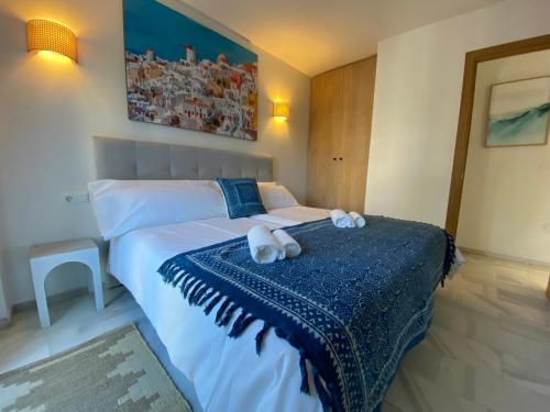 1 dormitorio con 1 cama con 2 toallas en Nomad Stays Milos y Bali, en Marbella