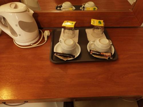 a tray with two tea cups and a coffee maker at Piraeus Acropole Hotel in Piraeus