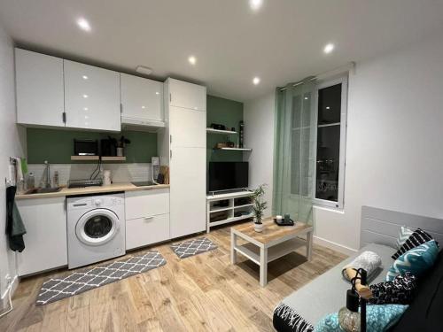 Il dispose d'une cuisine et d'un salon avec un canapé et un lave-linge. dans l'établissement Cosy appartement / stade de France / portes paris, à Saint-Denis