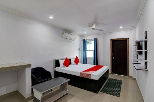 a room with a bed and a chair in it at Super OYO Flagship Blue Beach Cottage in Gopālpur