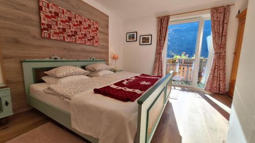 a bedroom with a bed and a large window at Haus Hepi B&B in Obertraun