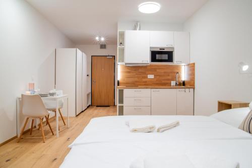 ein Schlafzimmer mit einem weißen Bett und einer Küche in der Unterkunft Ski&Bike Apartmán Blue in Janské Lázně