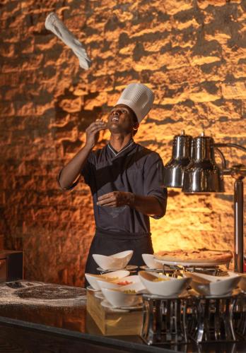 a man wearing a chef hat talking on a cell phone at The Golden Ridge Hotel in Nuwara Eliya