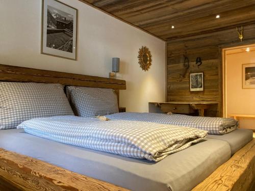 a bedroom with a bed with blue and white sheets at Öfnerhof in Leutasch