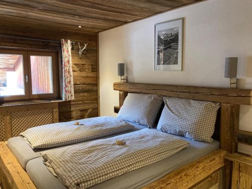 2 łóżka w sypialni z drewnianymi ścianami w obiekcie Öfnerhof w mieście Leutasch