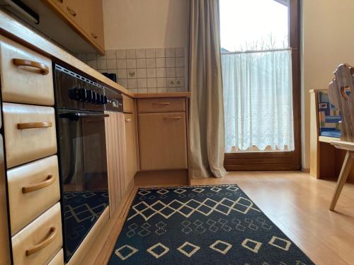 a kitchen with a stove and a kitchen rug at Öfnerhof in Leutasch