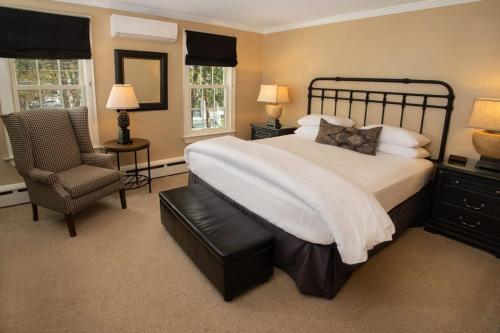 a bedroom with a large bed and a chair at The Dorset Inn in Dorset