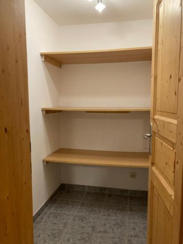 a walk in closet with wooden shelves and a door at Öfnerhof in Leutasch