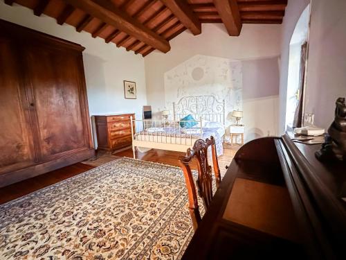 a bedroom with a bed and a rug on the floor at Tenuta Massabò in San Casciano in Val di Pesa