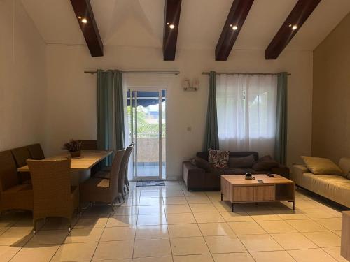 a living room with a couch and a table at Le Dattier - Three bedroom apartment - Coquillage in Flic-en-Flac