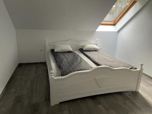 białe łóżko w pokoju z oknem w obiekcie Yacht Club Apartamenty w mieście Radzyń