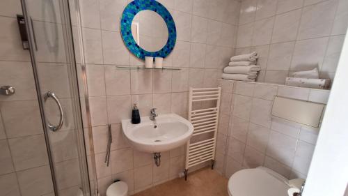 a bathroom with a sink and a mirror and a toilet at Haus Hepi B&B in Obertraun