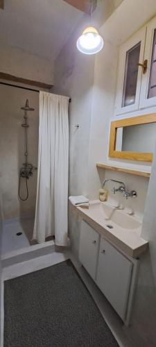 een badkamer met een wastafel en een douche met een douchegordijn bij THE GARDEN OF CHIOS in Chios