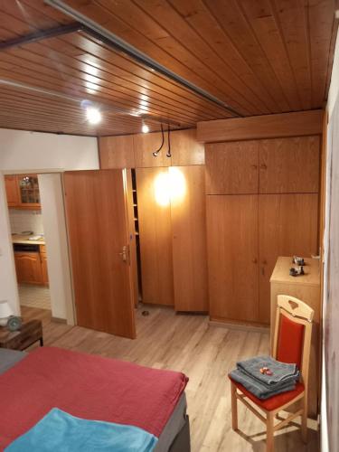 a room with a bed and a kitchen with wooden cabinets at Landhaus-Königsberg, Vorberg 360 Ebengütlweg in Ramsau am Dachstein