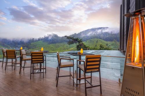 a table and chairs with a view of a mountain at The Golden Ridge Hotel in Nuwara Eliya
