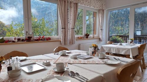 a dining room with two tables and large windows at Haus Hepi in Obertraun