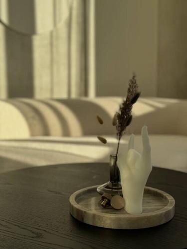a vase with a plant in it on a table at Danės23 - CANDY studio, Self Check-in, Free Parking, Park and River View, Oldtown, A/C in Klaipėda