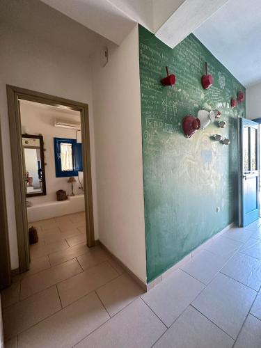 a room with a green wall with apples on it at Blue Meadow in Livadi Astypalaias
