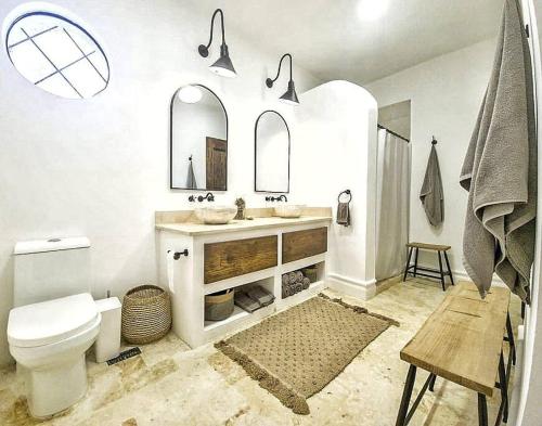 a bathroom with a toilet and a sink and mirrors at Beautiful villa with pool in San Felipe de Puerto Plata