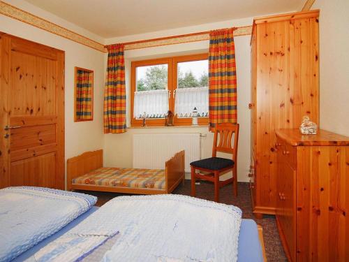 a bedroom with two beds and a chair and a window at Apartment house, Lütow in Lütow