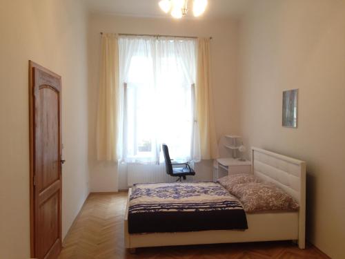 - une chambre avec un lit, une chaise et une fenêtre dans l'établissement Apartments near Lesser Town, à Prague