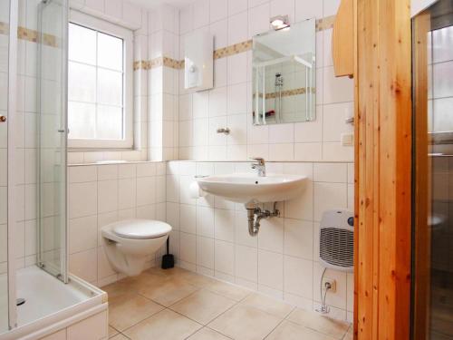 a white bathroom with a sink and a toilet at Semi-detached house Strandhaus I, Trassenheide in Trassenheide
