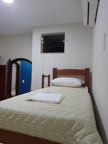 een slaapkamer met een bed met een handdoek erop bij Pousada Mundo Novo in Aparecida