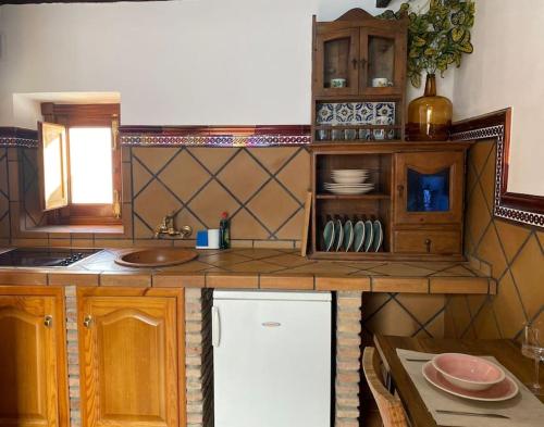 una cocina con encimera con fregadero y barra de sidx sidx en Casita Gazul, en Alcalá de los Gazules