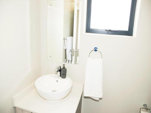 a white bathroom with a sink and a mirror at On New Luxury stay 2 WITH BACK UP POWER in Midrand