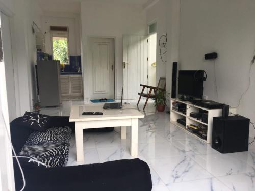 uma sala de estar com uma mesa branca e uma televisão em MIST em Ambalangoda