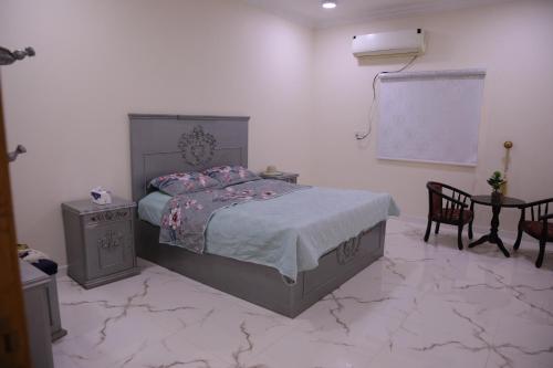 a bedroom with a bed and a white wall at شقق ريام جيزان للعوائل in Jazan