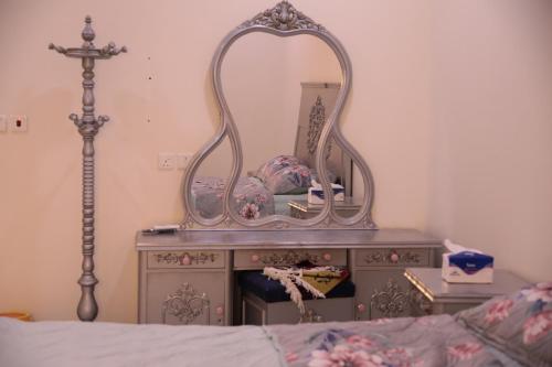 a mirror on top of a dresser next to a bed at شقق ريام جيزان للعوائل in Jazan
