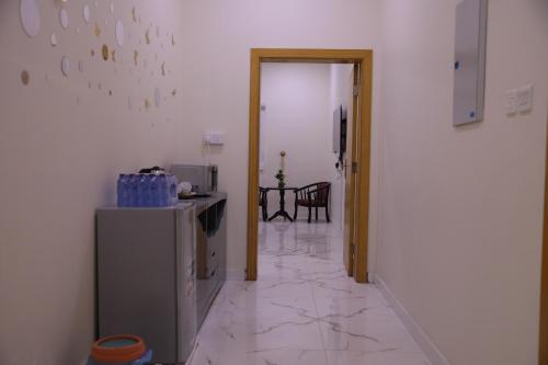 a hallway with a refrigerator and a table in a room at شقق ريام جيزان للعوائل in Jazan