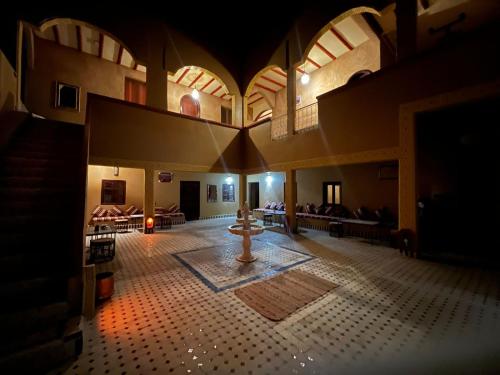 a large room with a fountain in the middle of a building at Camels House in Merzouga
