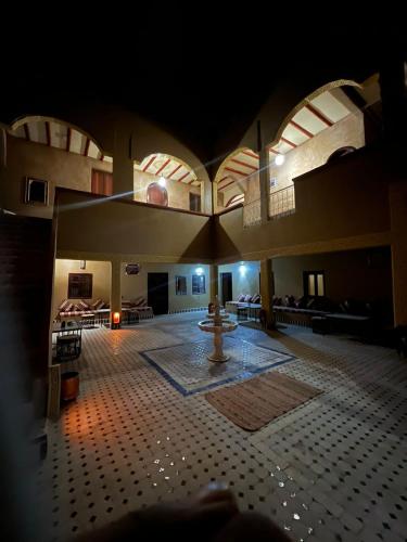 a large room with a fountain in the middle of a building at Camels House in Merzouga
