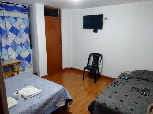 mały pokój z łóżkiem i telewizorem w obiekcie The Tourist House w mieście Ica