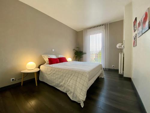 a bedroom with a large bed with red pillows at Appartement terrasse proche Versailles in Élancourt