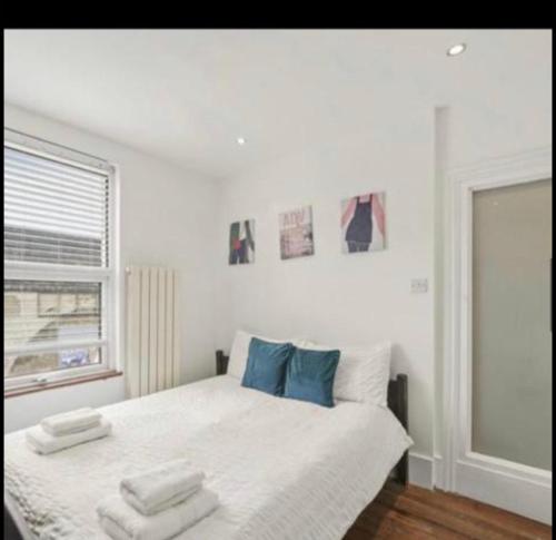 a white bedroom with a bed with blue pillows at Luxury city centre Apartment in London