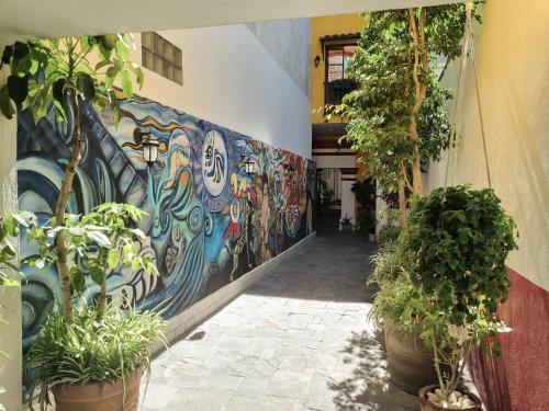 a mural on the side of a building with potted plants at Santa Josefita B&B in Cholula