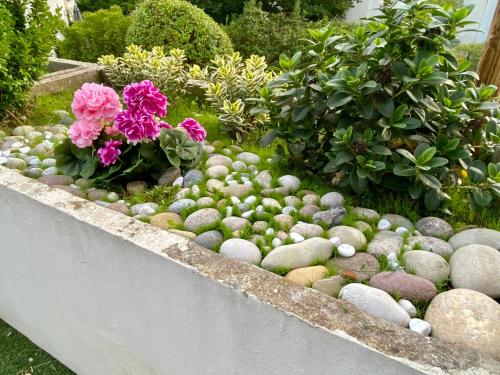 a garden with rocks and flowers and plants at Appartement terrasse proche Versailles in Élancourt