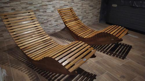 two wooden chairs sitting next to a brick wall at Hotel Slávie in Trhová Kamenice