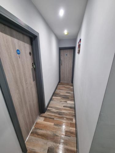 a hallway with two doors and a wooden floor at Sussex apartments 26A in Grimsby